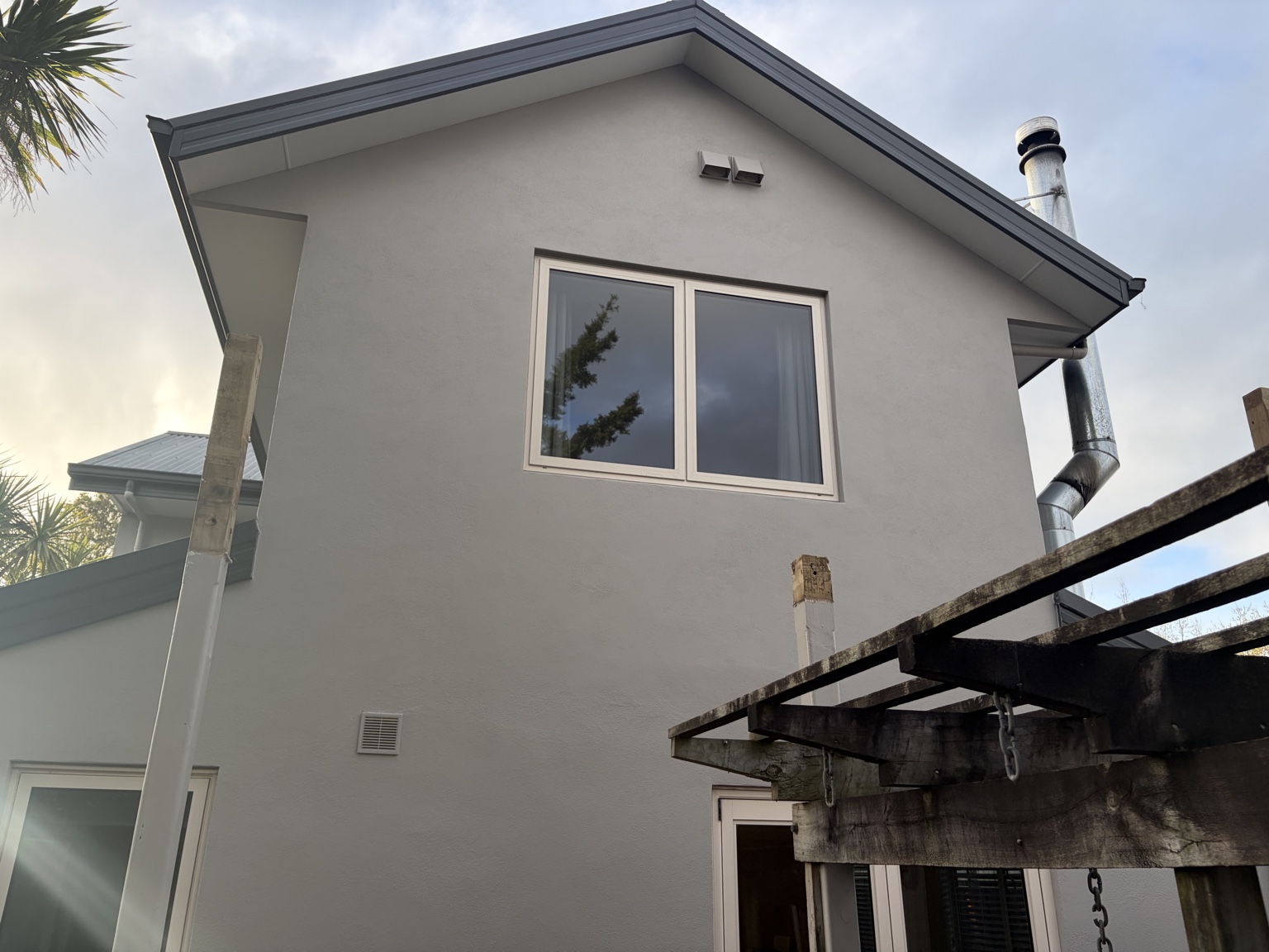 Completed exterior wall with new upper-level window after balcony removal