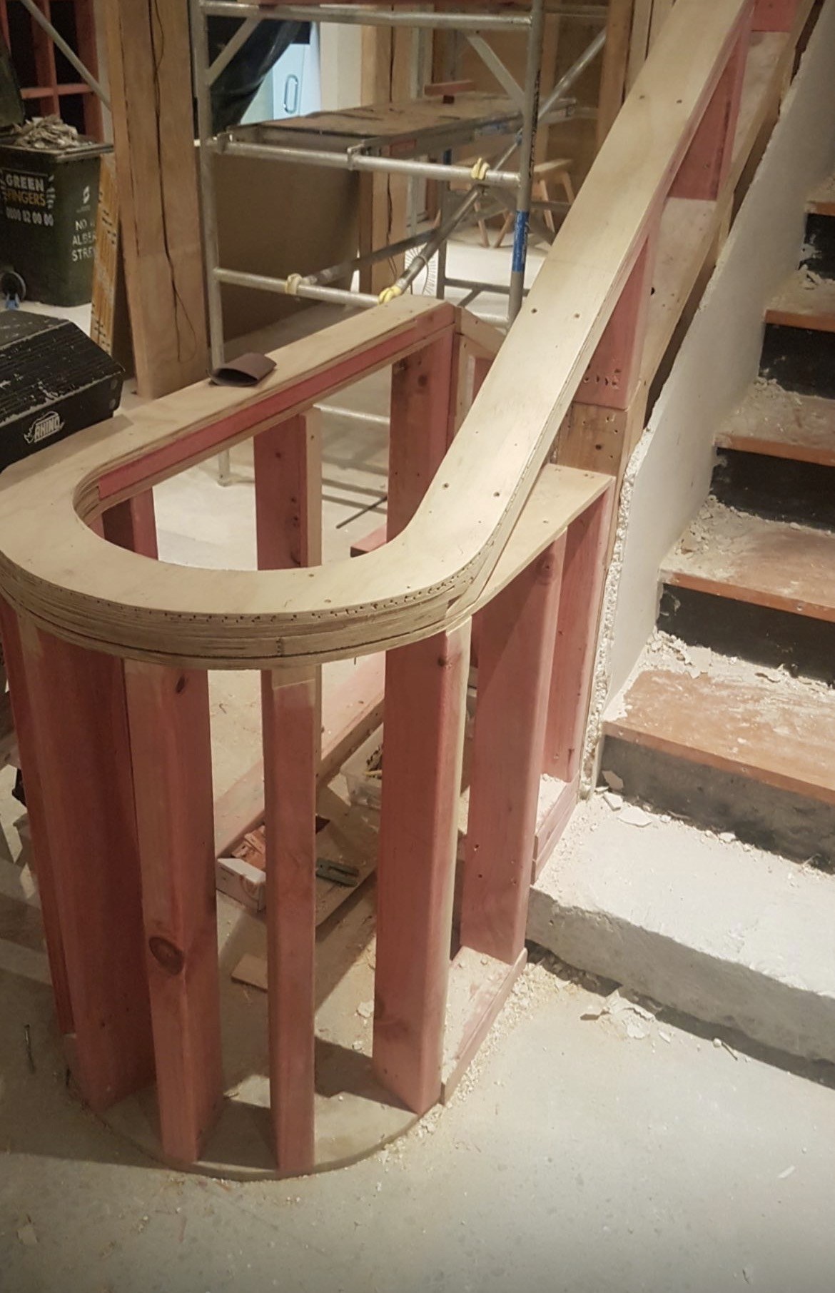 Curved timber wall framing and layered plywood forming behind the internal staircase at the Herne Bay refurbishment