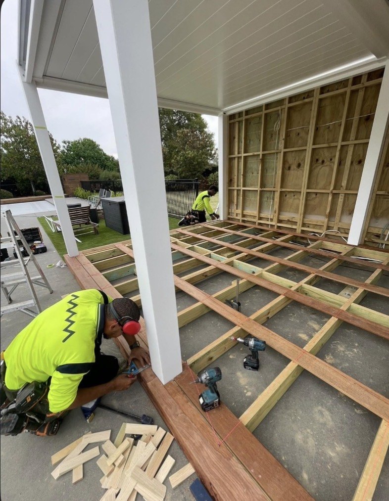 Fitting decking around the poolhouse posts.