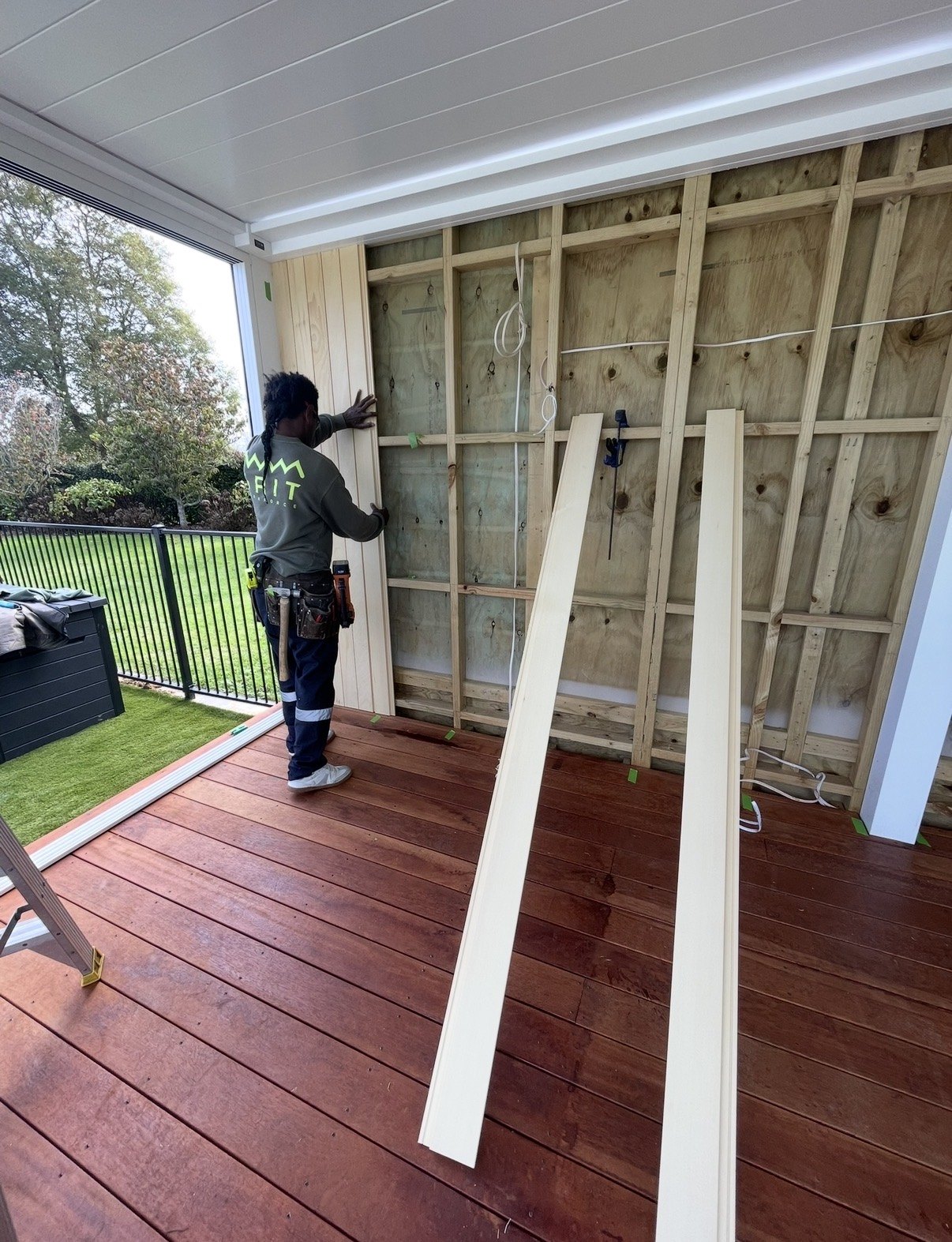 Installing the interior wall linings above the timber deck.